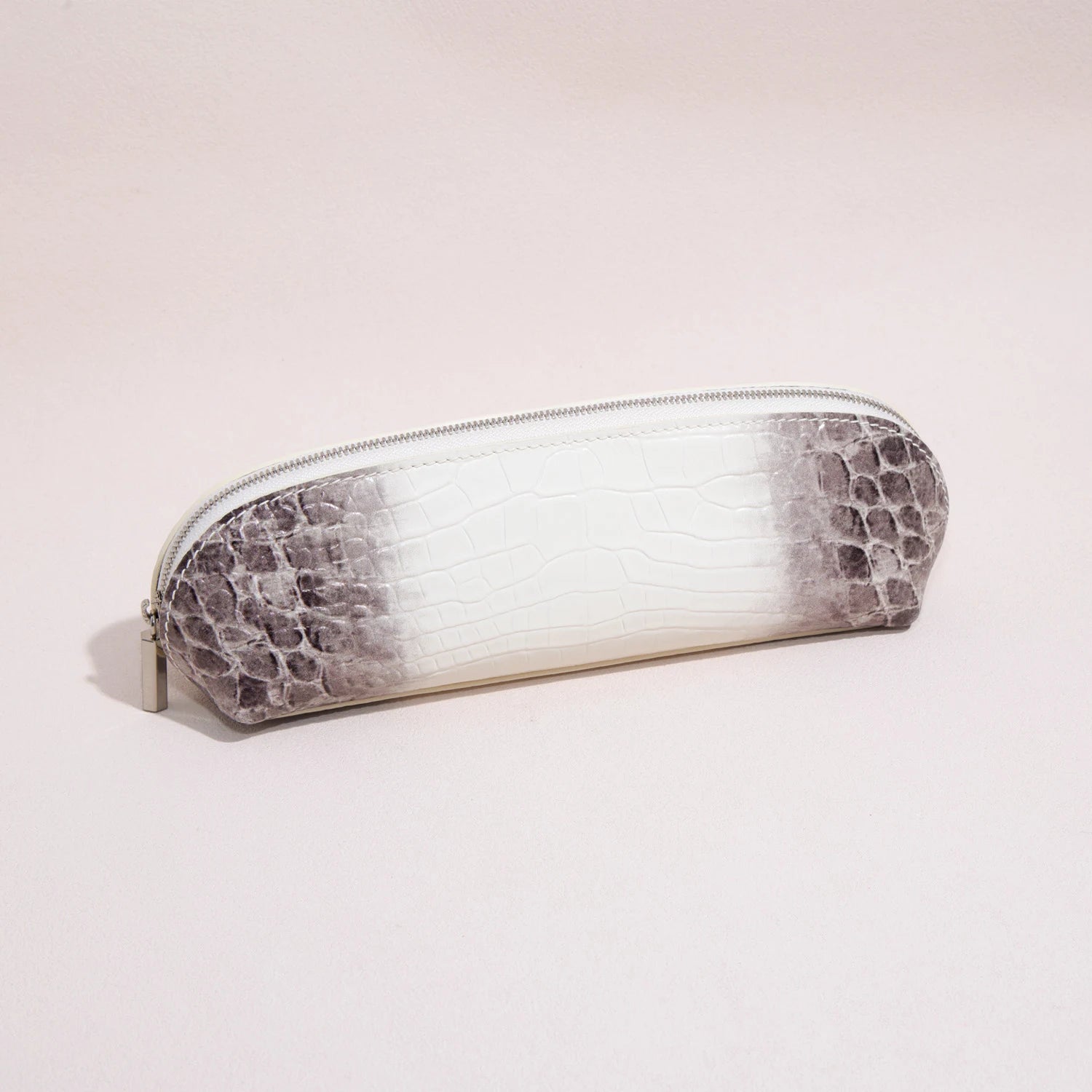 Close-up of the croc-embossed leather texture and silver-tone zipper on a slim pencil case