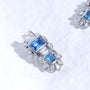 Blue gemstone ear charm with Swarovski crystal accents and silver-tone plated reliquary silhouette on a white textured surface