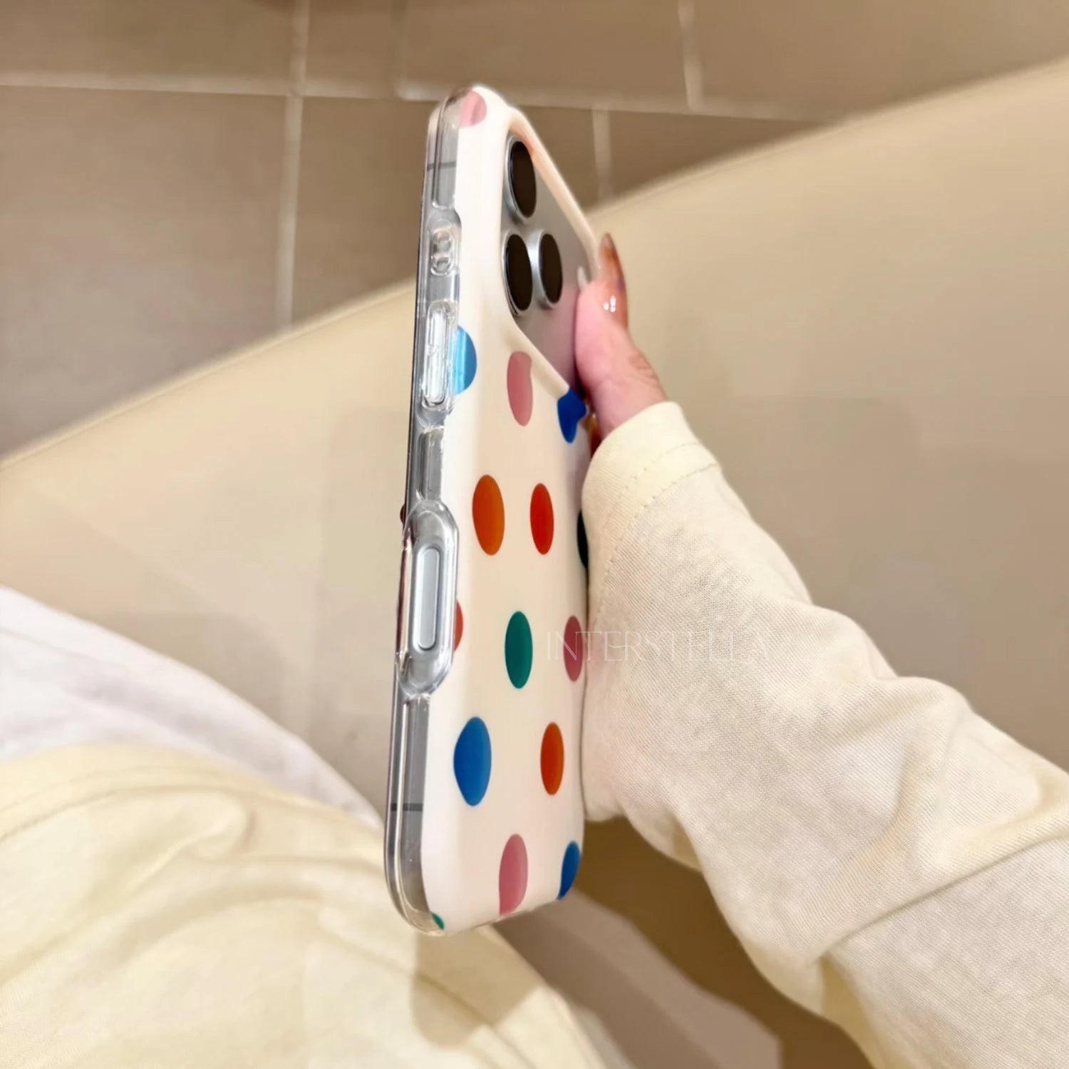 Side view of an ivory dot phone case with clear edges and covered buttons