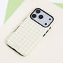 Buttercream gingham dual-layer phone case with a pale yellow and white check pattern, black side buttons, and raised black camera frame.