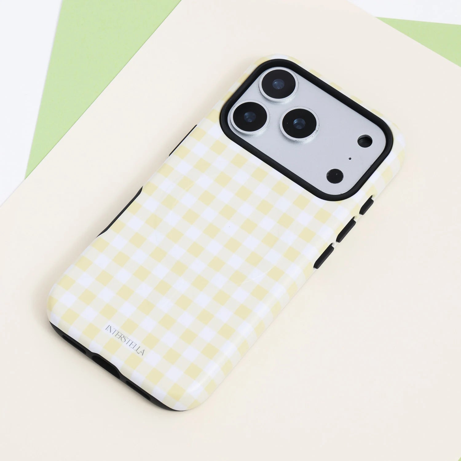 Buttercream gingham dual-layer phone case with a pale yellow and white check pattern, black side buttons, and raised black camera frame.