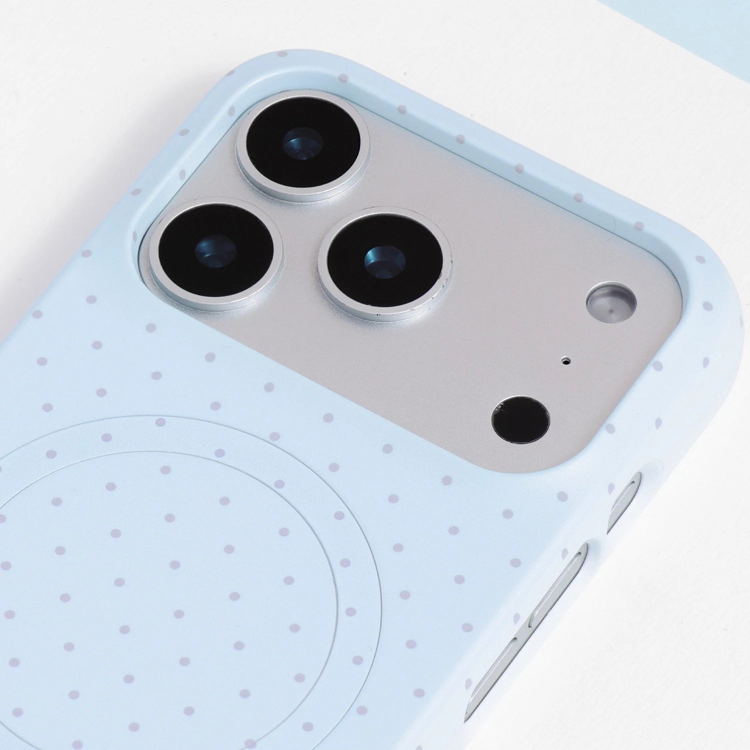 Close-up of the powder blue polka dot phone case camera area, showing the soft pastel tone and precise cutouts.
