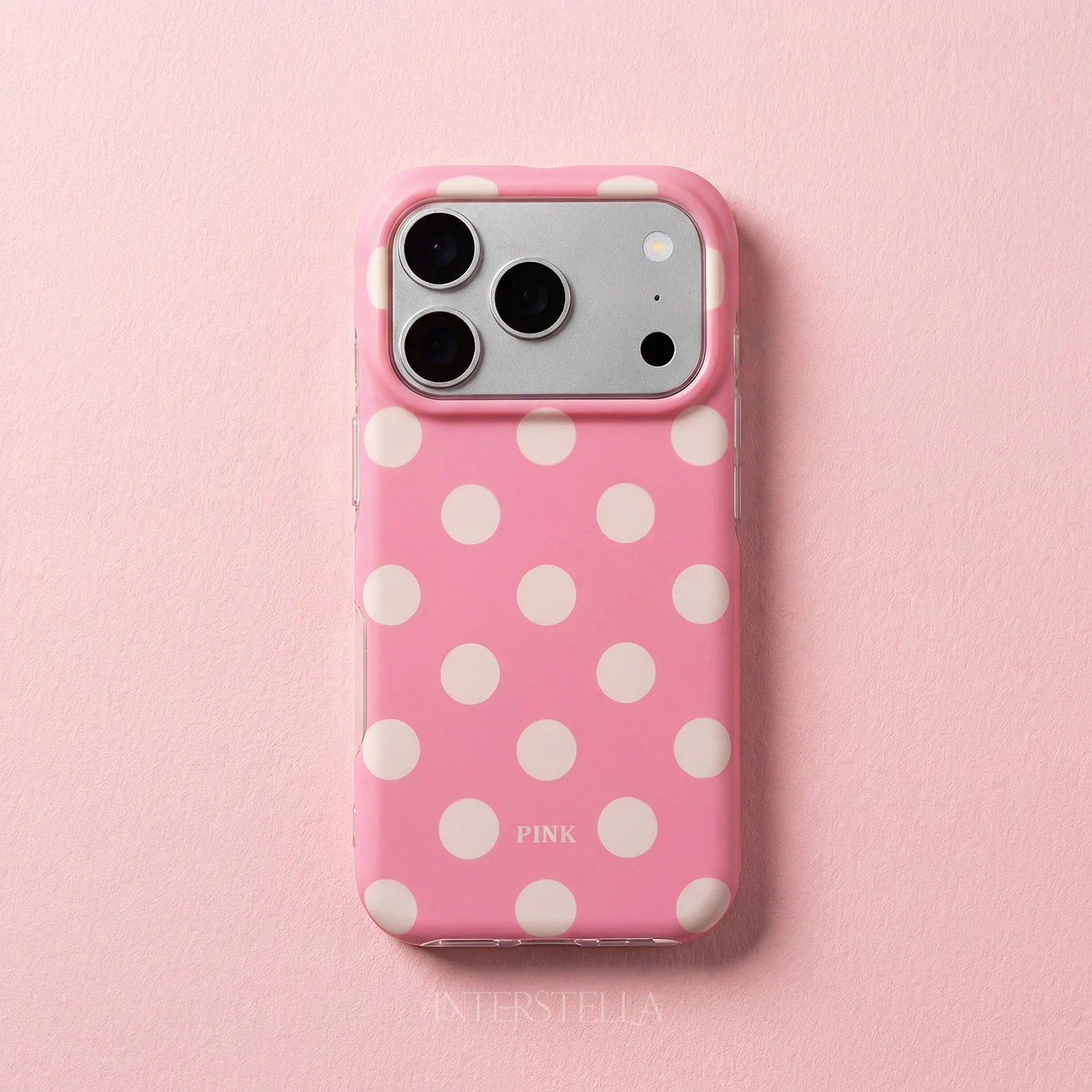 Candy pink polka dot phone case with ivory dots and raised camera surround on a pastel pink background.