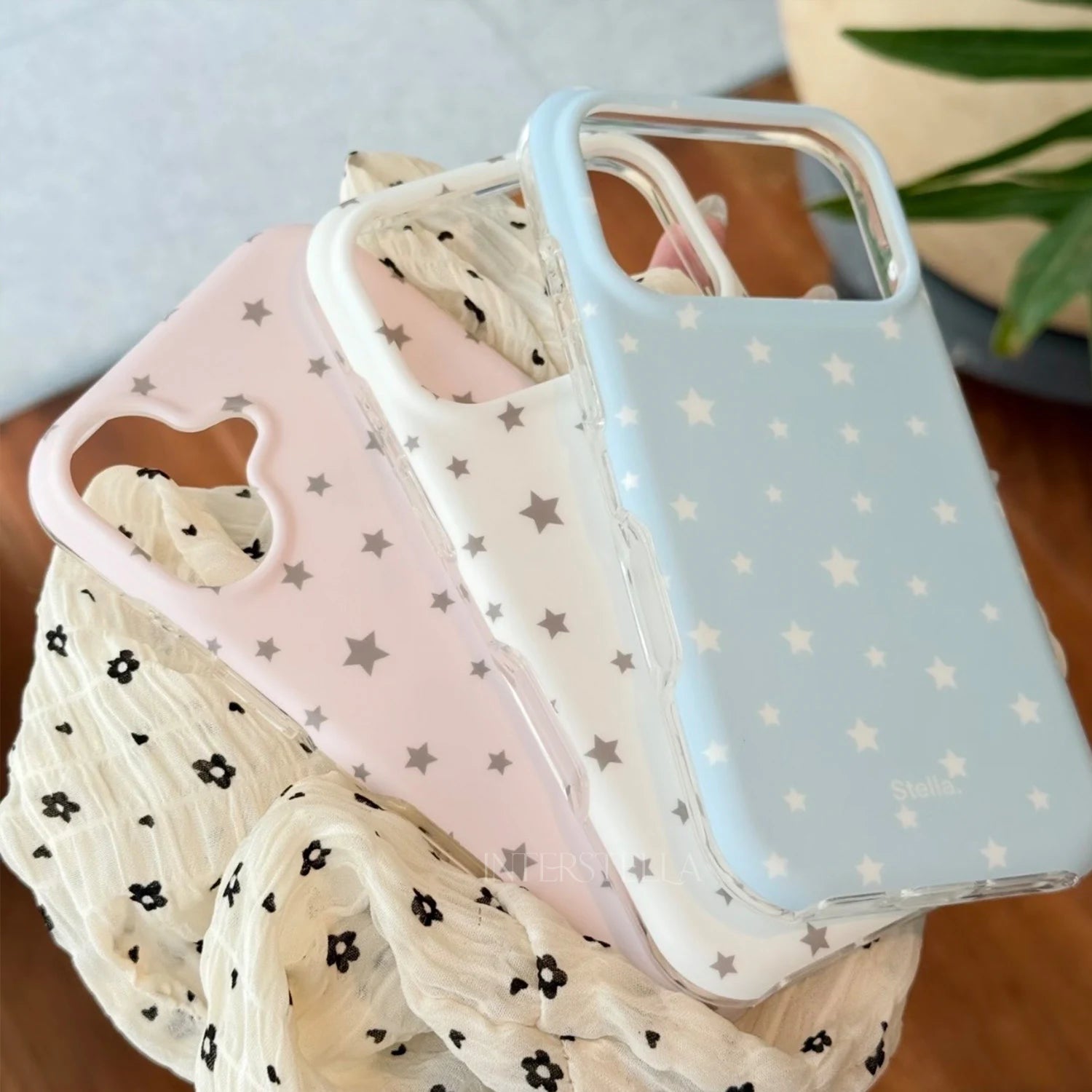 Pastel matte star phone cases in pink, white, and blue displayed together on soft fabric