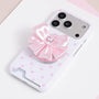 Blush pink jewel bow phone grip stand mounted on a pale pink polka dot phone case.
