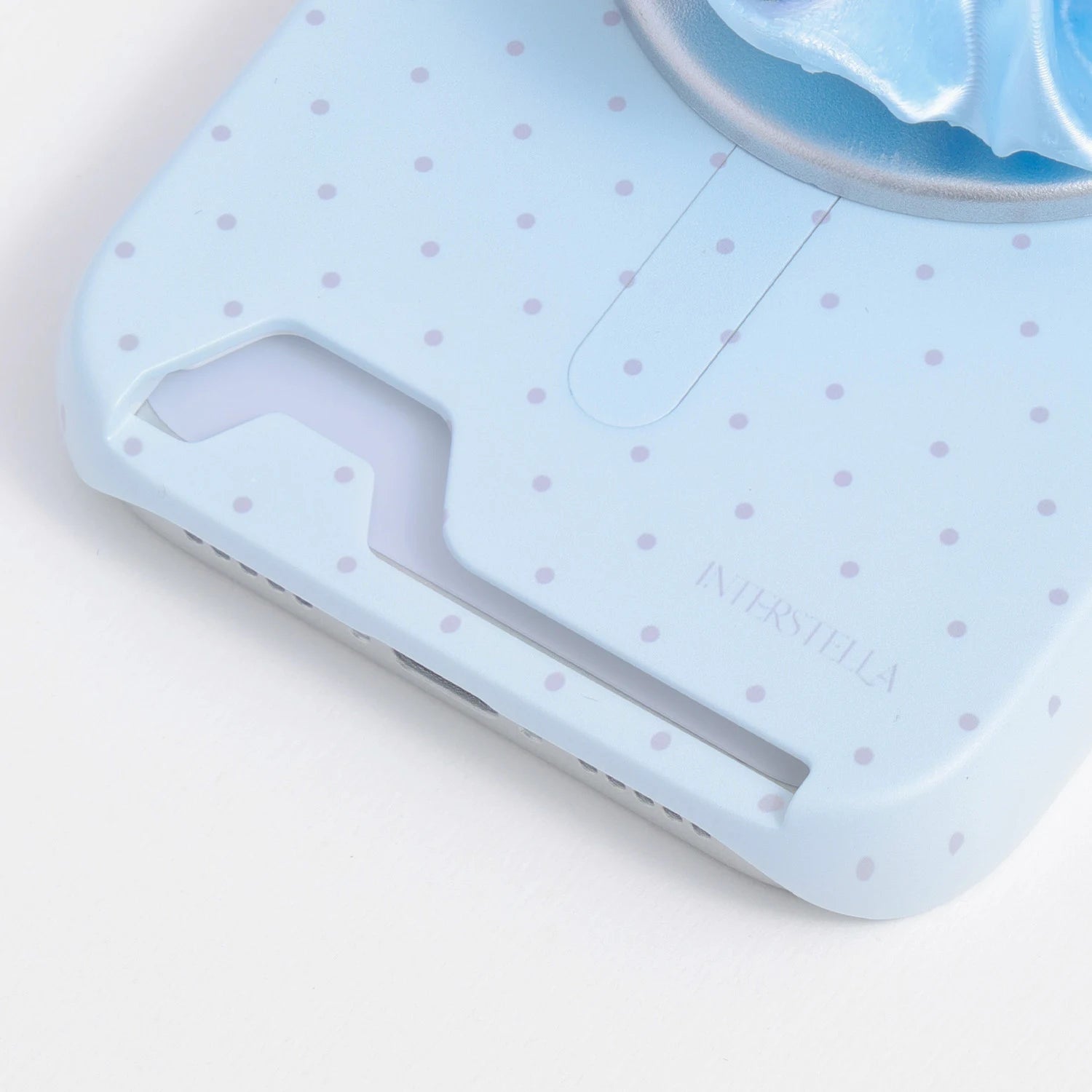 Close-up of the powder blue polka dot phone case bottom section, highlighting the built-in card insert slot.
