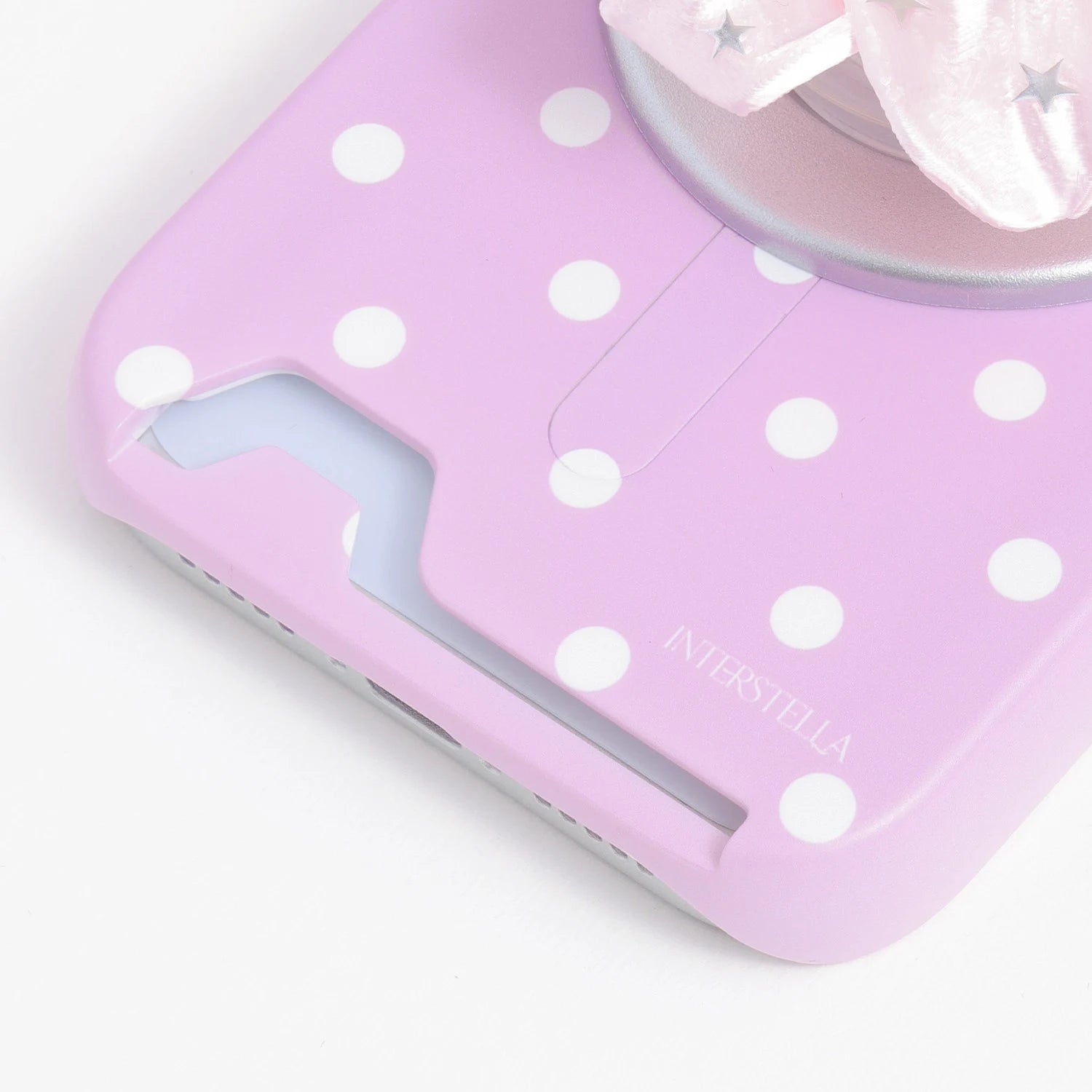 Close-up of the blush pink oversized polka dot card phone case bottom slot showing the built-in card insert opening.