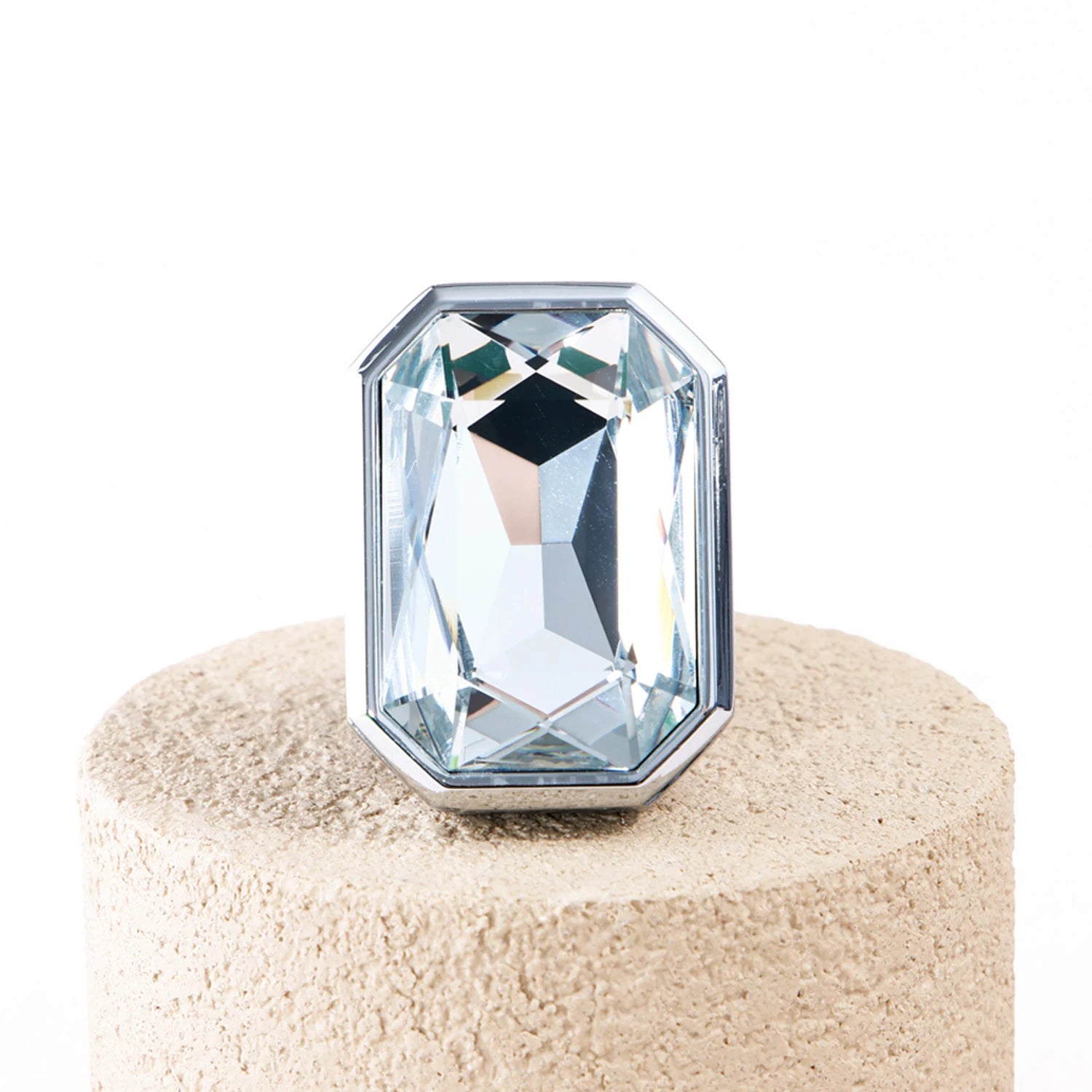 Front view of Palladio Prism crystal car diffuser with large rectangular gemstone-style crystal on beige stone
