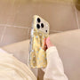 Side view of a gold shimmering star phone case with pale blue stars held in hand