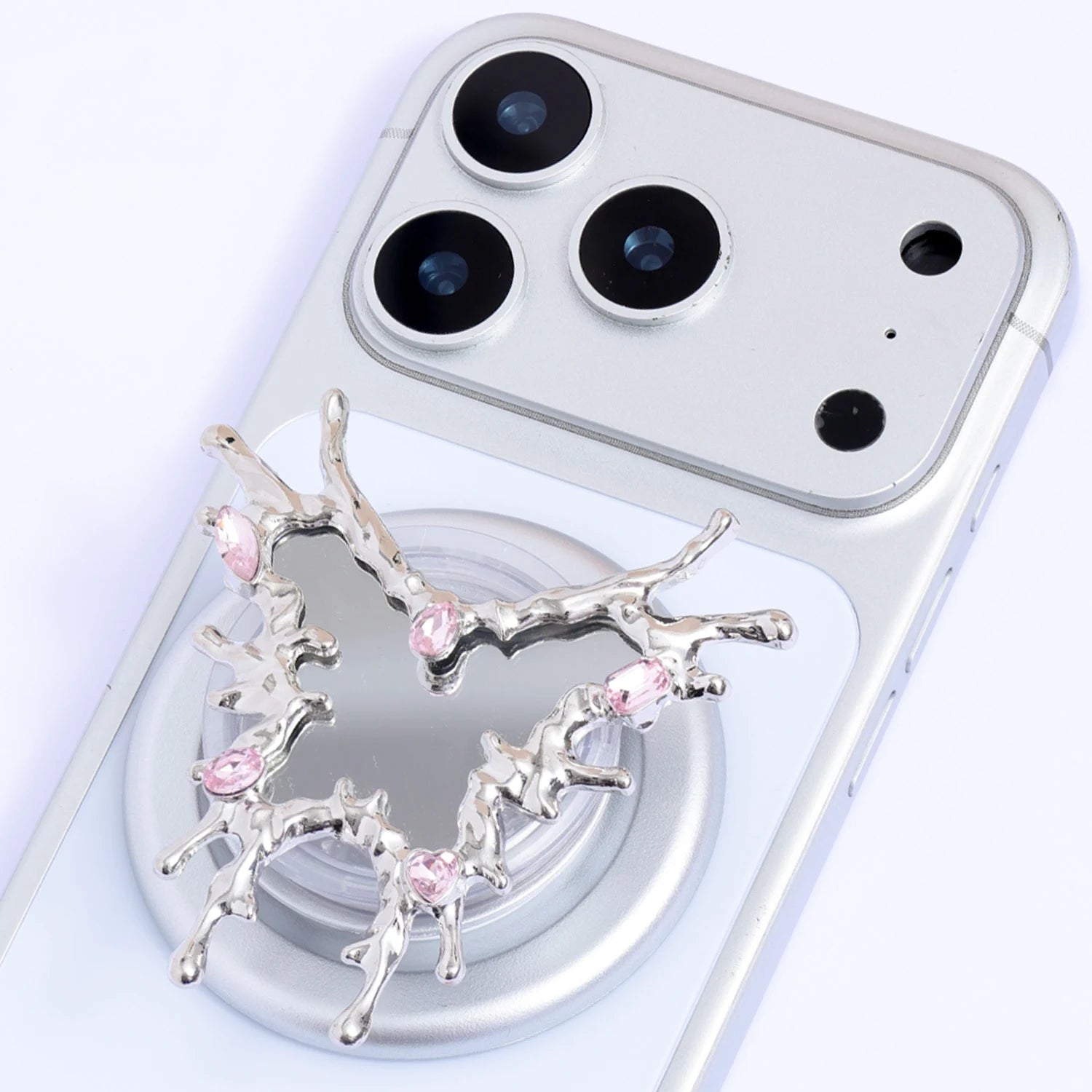Close-up of the Thorn Cross phone stand showing the branching silver-toned silhouette, mirrored center, and blush crystal accents.