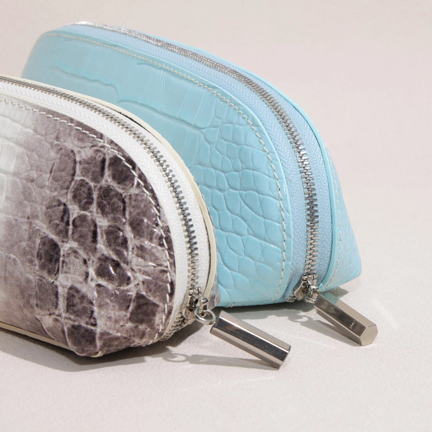 Two slim croc-embossed brow pencil cases displayed side by side in elongated rectangular forms
