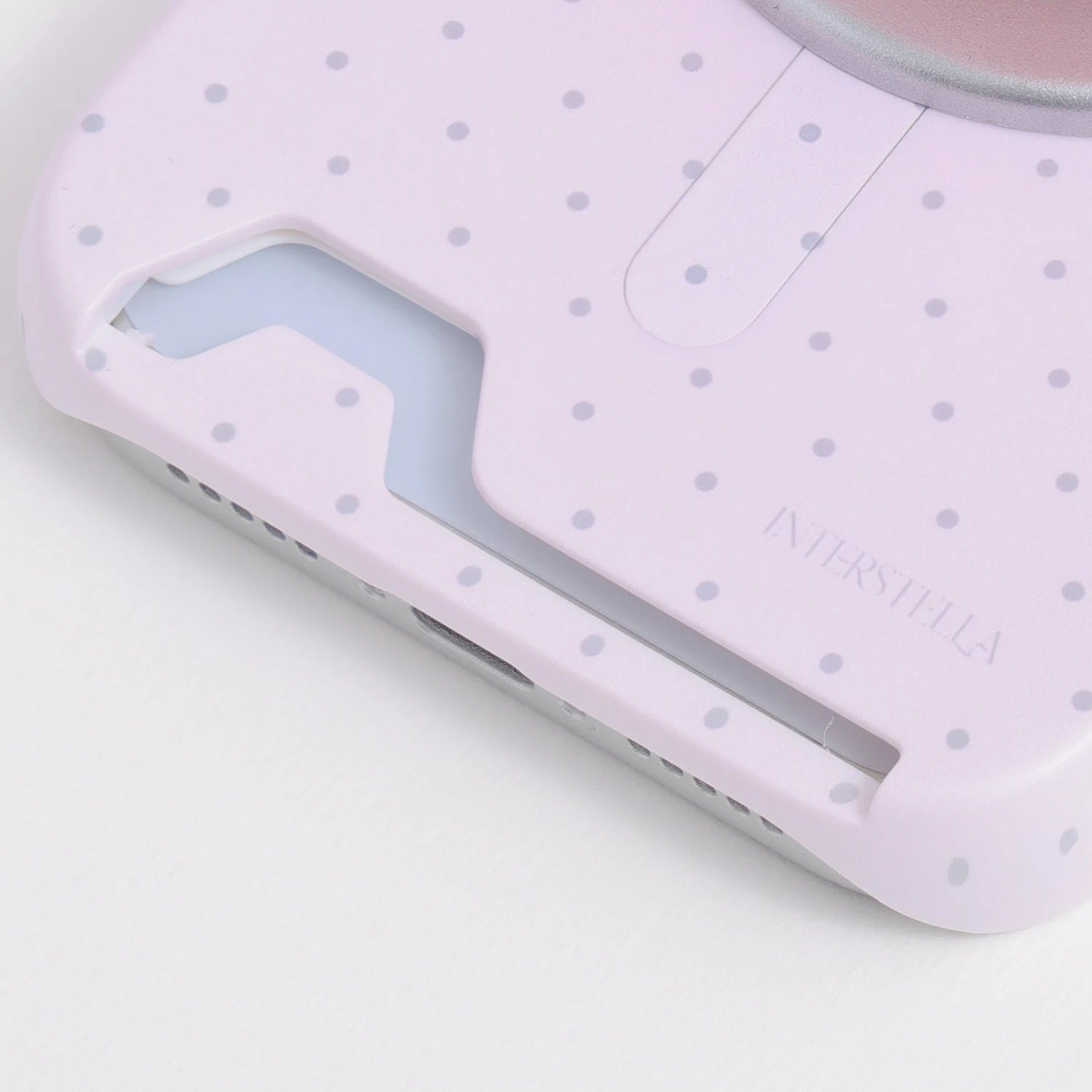 Close-up of the blush pink polka dot phone case bottom section showing the integrated card slot opening.