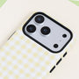 Close-up of the Buttercream gingham phone case featuring the pale yellow check pattern, smooth structured surface, and raised black camera frame.