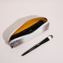 Open rectangular brow pencil pouch holding makeup brushes inside a structured leather case