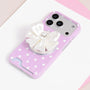 Ivory jewel bow phone grip stand attached to a pink polka dot phone case.