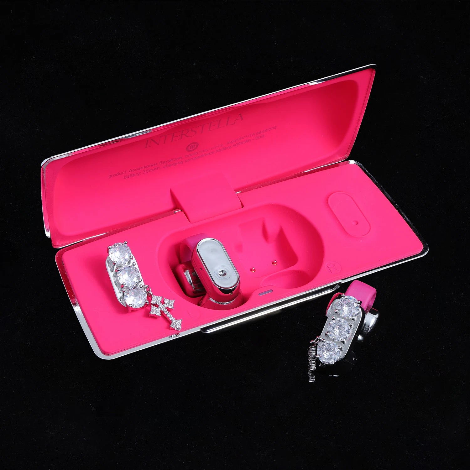Crystal ear charms with cross detail displayed with pink Interstella magnetic earphone charging case