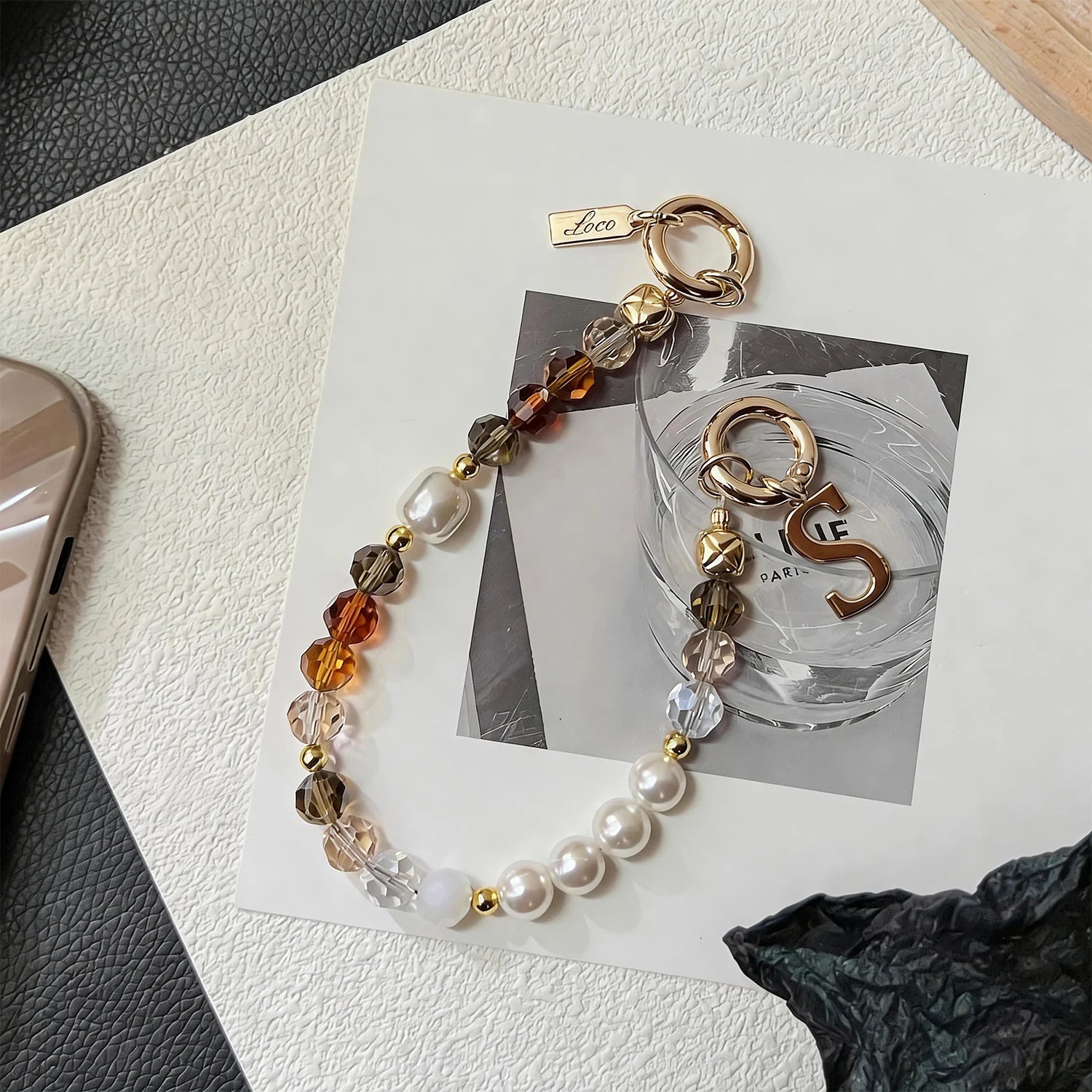 Handcrafted crystal and freshwater pearl phone strap with mixed metal accents and decorative clasp
